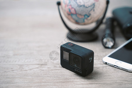 2018年月日新的哥普罗英雄7号黑动作相机配有旅行附件装在木制背景上图片
