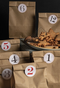上面有数字的纸袋和一份有姜饼干的盘子手工制作的冒险日历图片