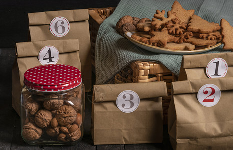 带有纸袋和数字的冒险日历概念一罐胡桃和杏仁一盘姜饼干图片