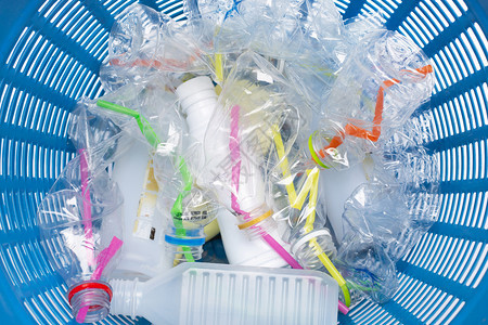 塑料废物垃圾篮中装有稻草的塑料瓶图片