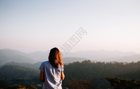 女人在山顶仰望山峰图片