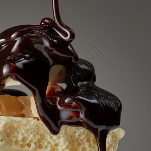 巧克力糖浆被倒在白色巧克力块上与黑色隔绝Syrop倒在一块巧克力上图片