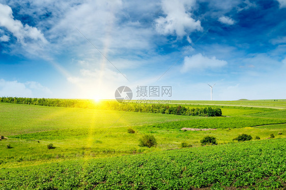 山丘绿地太阳升起风车在蓝天空背景农业地貌图片