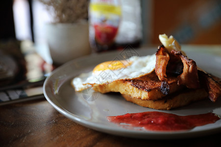 华夫饼煎蛋沙拉早餐法式烤面包加培根鸡蛋和奶酪加果酱在木桌背景上背景