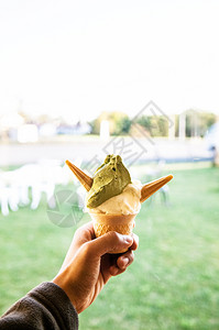 手头有一杯绿色茶红冰淇淋软奶油背景图片