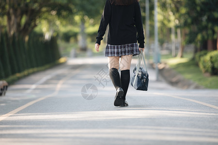 在公园户外电影陈年风格上行走的女学生服装肖像图片