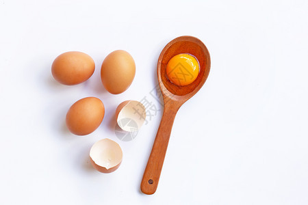 勺子上的蛋黄和旁边三颗完整的鸡蛋图片
