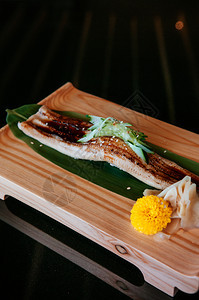 木板上加厚的寿司整块大的日本面鱼寿司深底色温暖的音调图象图片