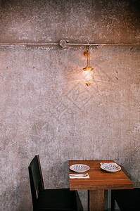 2013年第jan23年泰兰邦Bangko现代餐桌和椅子配有旧水泥墙和古灯的暖音光图片