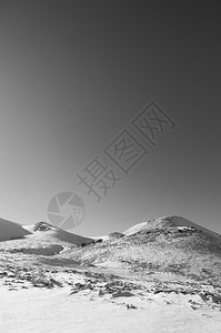 冬季在晴天的上满是雪的火山黑色和白的图像图片