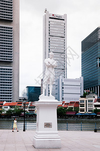 2013年12月19日新加坡莱佛士登陆地的斯坦福德莱佛士爵士白石雕像他将渔人村改造成了新加坡港口城市码头边有现代化的办公楼图片