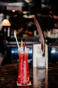 大理酒吧一杯红莓配上指根草药用黑色大理石柜台上的创意鸡尾酒背景