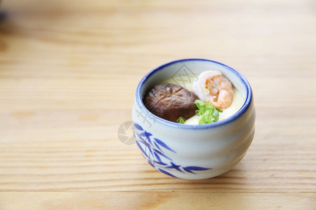 陶瓷碗里的蒸鸡蛋加蘑菇和虾仁图片