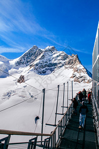 瑞士游客对中丘弗劳霍赫峰和欧洲观察甲板顶端的全景瑞士雪山峰图片