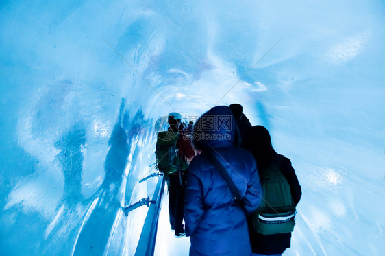 瑞士游客走在冰洞里面图片