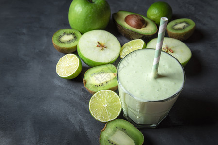 在灰色厨房桌边的玻璃和绿色水果上新鲜的健康冰沙饮食环境素品脱毒概念复制空间图片