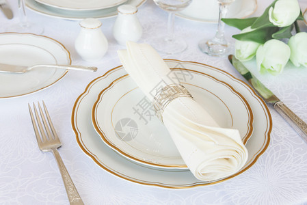 经典盛宴晚与豪华的瓷银餐具和白桌布上的郁香花图片