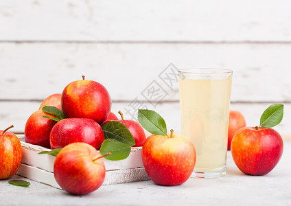 玻璃新鲜有机苹果汁健康红盒装在木质背景空间的文字图片