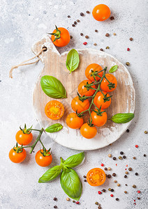 葡萄藤上的有机樱桃橙红番茄在石本底的砍刀板上加和胡椒图片