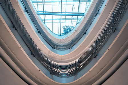 未来建筑玻璃天花板和螺旋栏杆在现代购物中心明亮的蓝光在斯图加特市德国图片