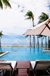 2014年6月日2014年华欣泰国热带海边度假胜地风格的无穷热带海边度假胜地缘泳池夏天在白色雨伞和椰子树下有海滩床和图片