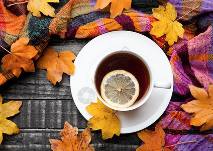 茶杯加柠檬围巾和木本底秋叶图片