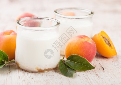 鲜奶油甜点和木板上的生有机杏子图片