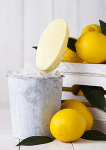 用柠檬冷冻果汁雪糕制成的冰淇淋放在死桶里和一箱生柠檬图片