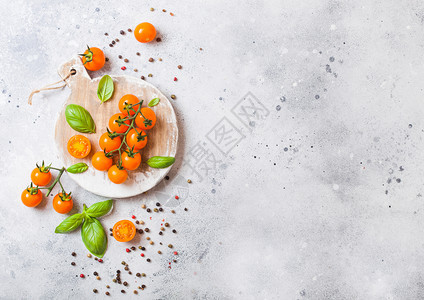 葡萄藤上的有机樱桃橙红番茄在石本底的砍刀板上加和胡椒图片