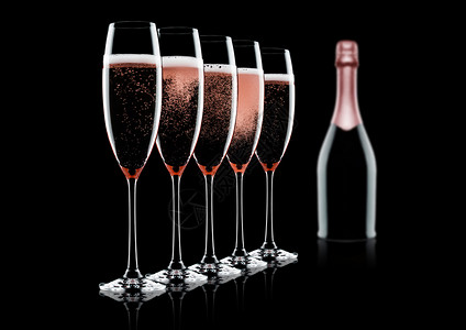 粉红香槟酒杯和瓶黑色背景反光图片