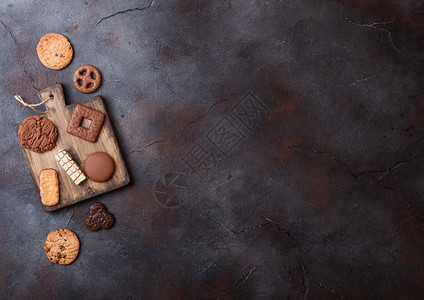 在石头厨房背景的木板上挑选燕麦和巧克力饼干图片