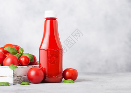装有番茄酱的塑料容器和厨房背景的生番茄图片