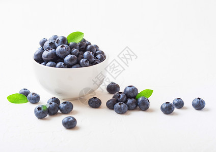 原生有机蓝莓白瓷碗叶色背景背景图片