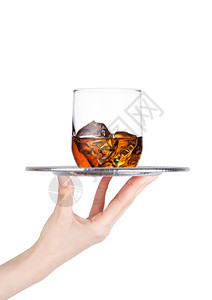 手持盘在白色背景上加杯威士忌和冰块图片