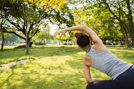 年轻健康青的跑女子在运动前给身体取暖在温的清晨公园湖边做瑜伽在城市概念中生活方式健康跃的妇女运动图片
