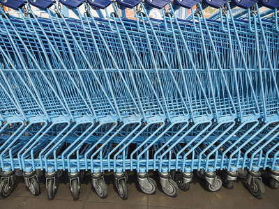 摆放在超市入口的一排蓝色购物车图片