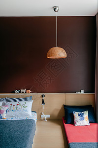 2014年6月日2014年bangko泰国现代卧室的merlot红色墙壁上面有多彩的亚洲壁炉枕头竹天花板灯和床被木墙击中现代家庭图片