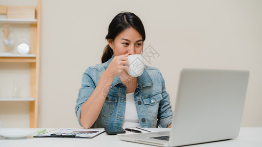 asi商业女在家庭办公室从事文件财务和计算工作在家享受时间图片