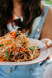 女人拿着泰河街食物烹饪菜盘沙拉加辣番茄沙拉和炸鱼蛋糕图片