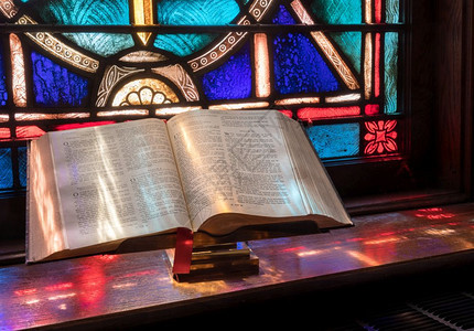 美式教堂的彩色玻璃窗光照着开放的圣经美式教堂的彩色玻璃窗光照着开放的圣经背景图片