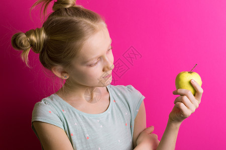 粉红背景的金发小美女摆姿势拍照片图片