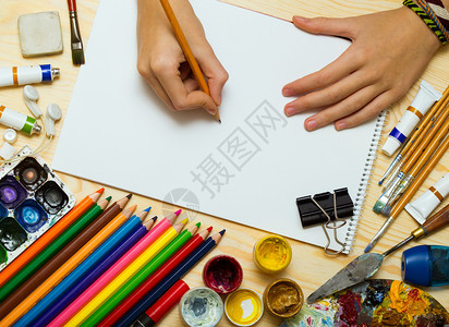 女孩艺术家的手和专辑页油漆铅笔土木画背景的笔图片