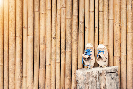 一对老式经典运动鞋靠在竹墙上旅行概念背景图片