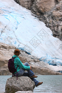 坐在石头上看着冰川图片