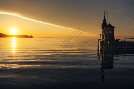码头和小灯塔清晨在湖中康斯坦兹和一座小灯塔上日出在德国康斯坦兹的水湖中反射风景平息背景
