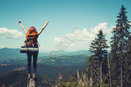 在山林背景上站着的女孩徒步旅行者图片