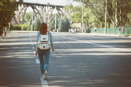 带着背包的女孩在空路上行走图片