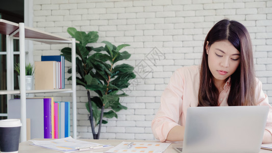 asi商业女在家庭办公室写笔记本文件财务和计算器享受家庭概念图片