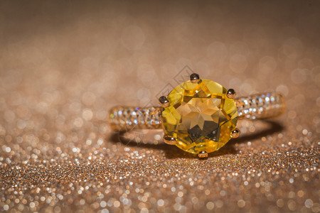 黄色钻石黄金环有闪亮的柑橘宝石背景