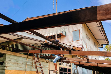 可能1029Chacoengsa泰国古老的木屋利用亚洲劳工在日光天对蓝的木屋顶铁轨结构上摇摆翻修建筑的老木屋图片